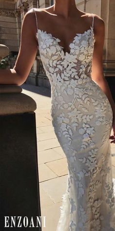 a woman in a white wedding dress posing for the camera with her hand on her hip