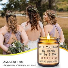 two women in dresses standing next to each other holding flowers and looking at the same candle