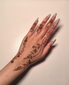 a woman's hand with henna tattoos on it