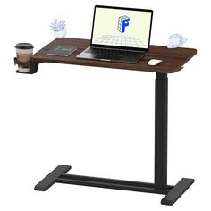 a laptop computer sitting on top of a wooden desk next to a cup of coffee