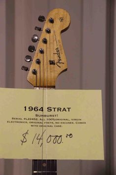 an electric guitar is on display with a sign in front of it that says,'1965 strat sunburst