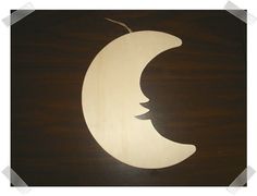 a wooden cutout of a crescent moon on a dark wood background with white trim