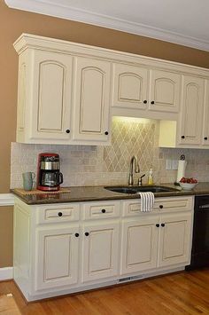 a kitchen with white cabinets and black appliances