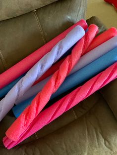 four different colored toothbrushes sitting on top of a couch