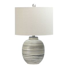 a black and white striped lamp with a beige shade on the bottom, sitting next to a white linen lampshade