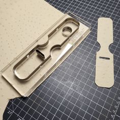 a pair of scissors sitting on top of a piece of paper next to some cutters