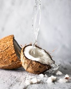 the coconut is cut open and being filled with water