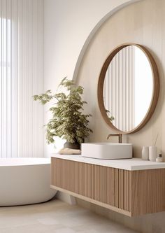 a white bath tub sitting next to a wooden counter top under a round shaped mirror