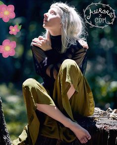 a woman sitting on top of a tree stump with her arms around her neck and legs crossed