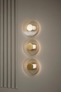 three circular lights are mounted on the wall