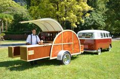 a man standing next to an old fashioned trailer