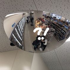 the reflection of two people standing in front of a store's window with an upside down mirror