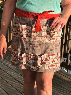 a woman standing on a deck with her hands in her pockets and wearing a skirt