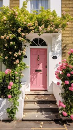 a pink door is surrounded by flowers and greenery