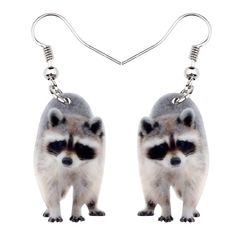 two raccoons are dangling from silver earrings