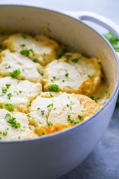 a pot filled with some food and garnished with parsley on the side