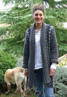 a woman standing next to a dog in a yard