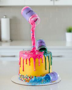 a cake with icing and sprinkles being poured onto it on a plate