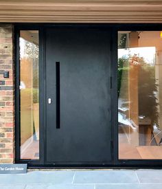 a black front door with glass panels on the outside