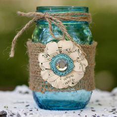 a blue mason jar with a flower on the lid and some string attached to it