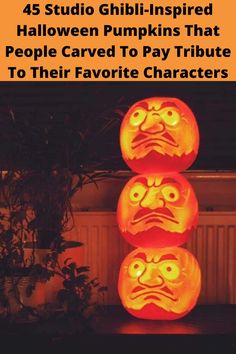 three carved pumpkins sitting on top of a table next to a potted plant