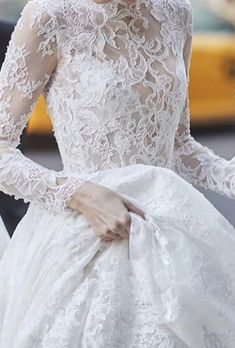 a woman in a wedding dress is walking down the street with her hand on her hip