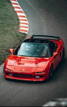 a red sports car driving down a race track