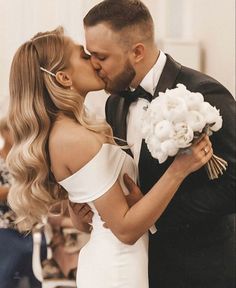 a bride and groom kissing at their wedding