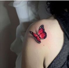 a woman with a red butterfly tattoo on her shoulder