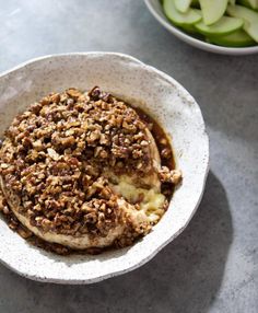 a white bowl filled with food next to an apple