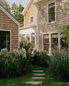 the house is tan with white trim and has stone steps leading up to it's front door