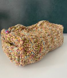 a crocheted purse sitting on top of a white table