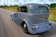 an old fashion car driving down the road