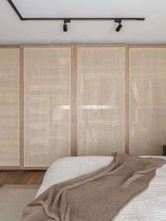 a bedroom with sliding closet doors and white bedding