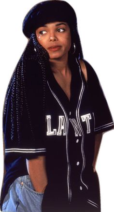 a woman wearing a baseball jersey with braids on her head and an earring