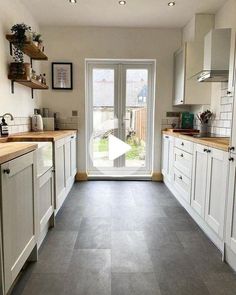 a kitchen with white cabinets and gray flooring