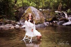 a woman sitting on a chair in the water