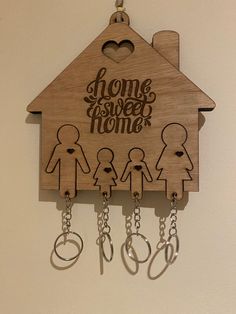 a wooden cuckoo clock with key chains hanging from it's sides and the words home sweet home