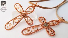 two copper dragonfly pendants sitting next to each other