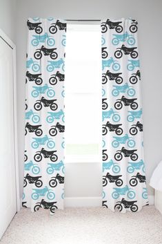 a room with a window, curtains and a cat on the bike pattern in blue