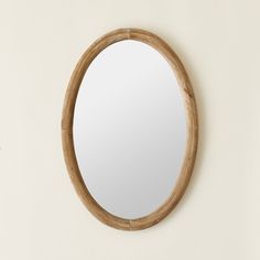 a round wooden mirror hanging on the wall