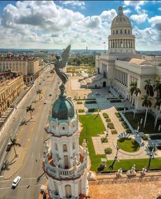 an aerial view of a large building with a bird on it's roof in the middle of a city