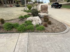 a black truck parked on the side of a road next to a rock and grass bed