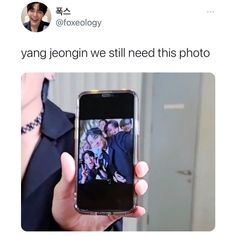 a person holding up a cell phone with an image on the screen and text that reads, yang jeonggin we still need this photo