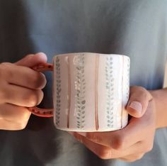 a person holding a coffee cup in their hands