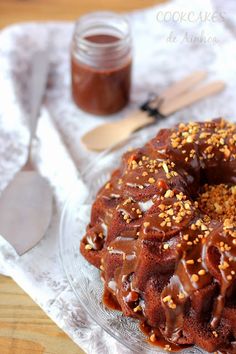 a bundt cake with chocolate glaze and sprinkles on a glass plate