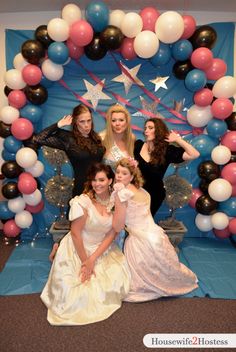 a group of women posing in front of a balloon arch