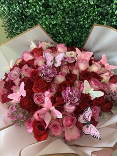 a bouquet of red roses and pink butterflies