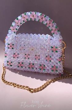 a handbag made out of plastic beads and chains on a white surface with a gold chain