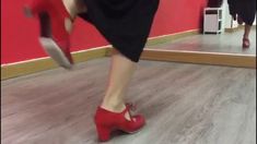 a woman in red shoes is dancing on the floor